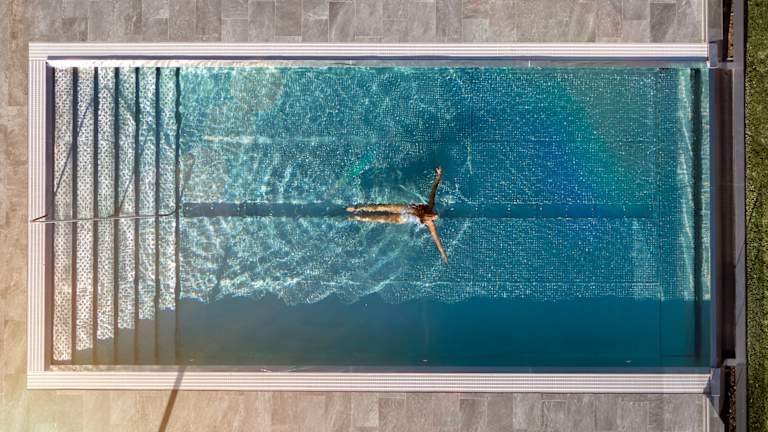 Kvinna som simmar i pool