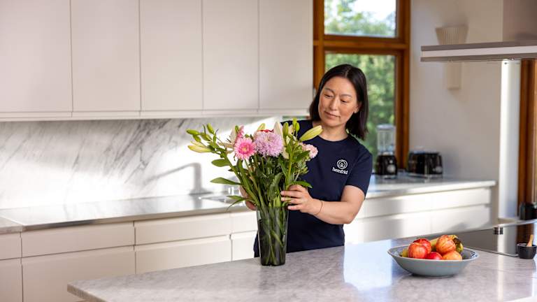 Kvinna som sätter blommor i en vas