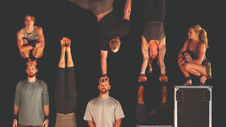 Fra forestillingen Ten Thousand Hours på Nøtterøy Kulturhus. Syv personer står på en scene med svart bakgrunn. 3 av dem står på hendene.