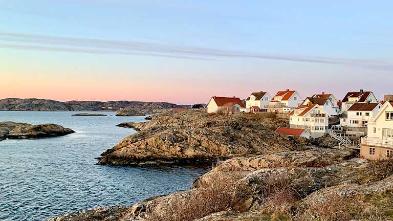 Bilde av et feriehus der du ser havet, basseng, en sofagruppe og en parasol.