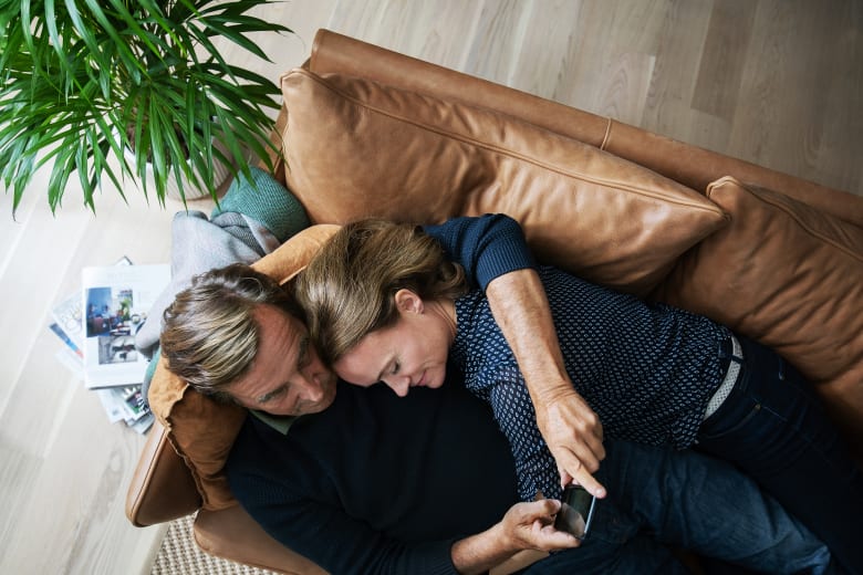Par på sofa scroller på mobil