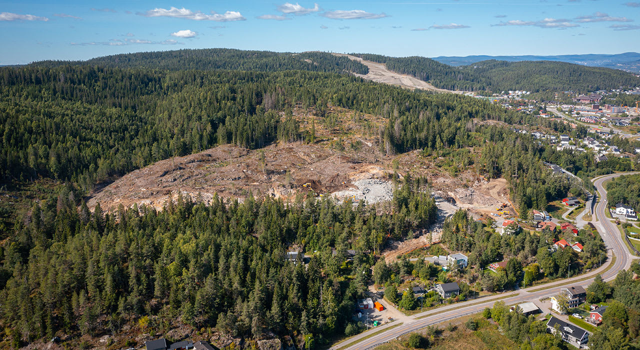 Tomta på Marikollåsen med vei og skog rundt