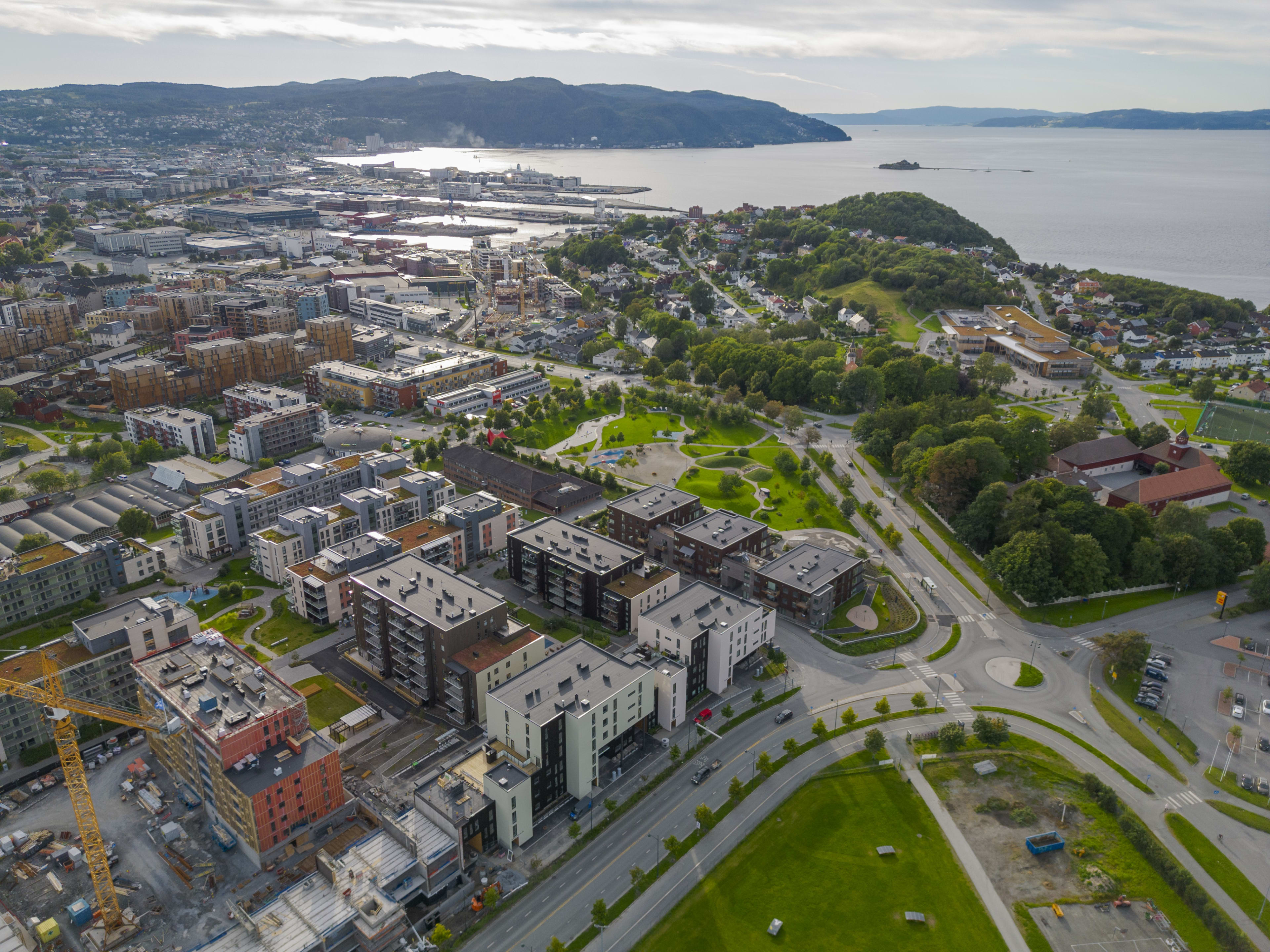 Dronefoto av hele området til Ladebyhagen med alle byggene, rett ved parken, vannet og fotballbane.