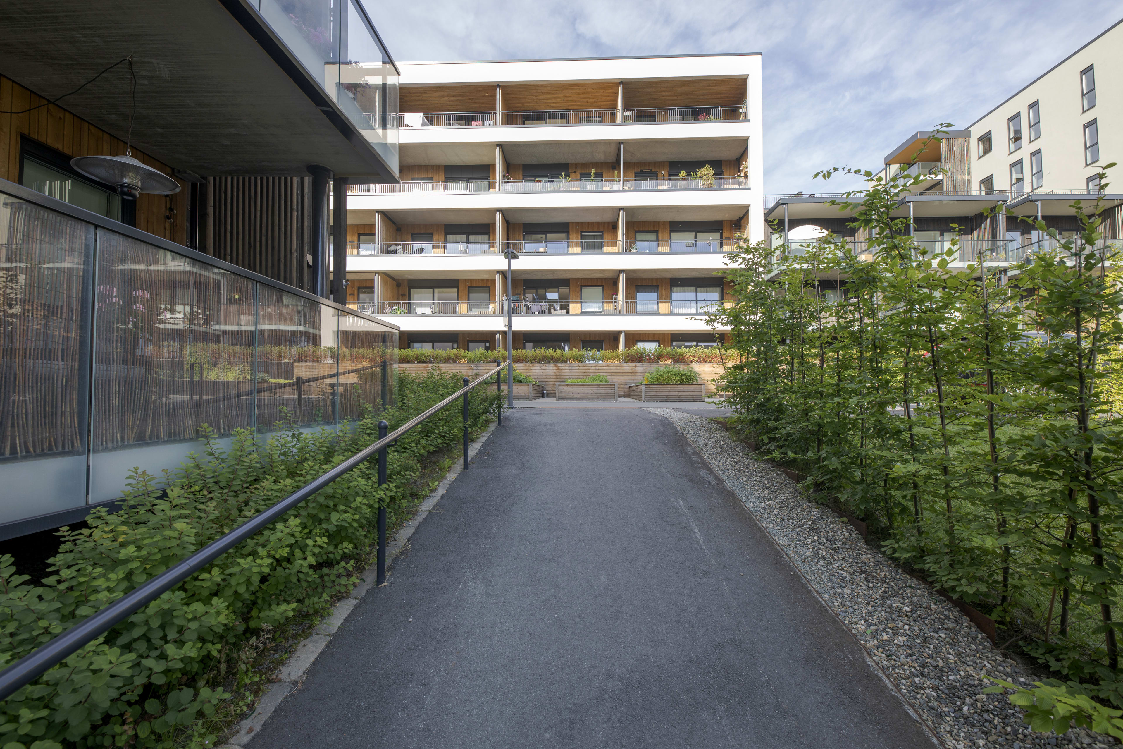 Foto av fasaden til byggene med gangvei i Ladebyhagen.