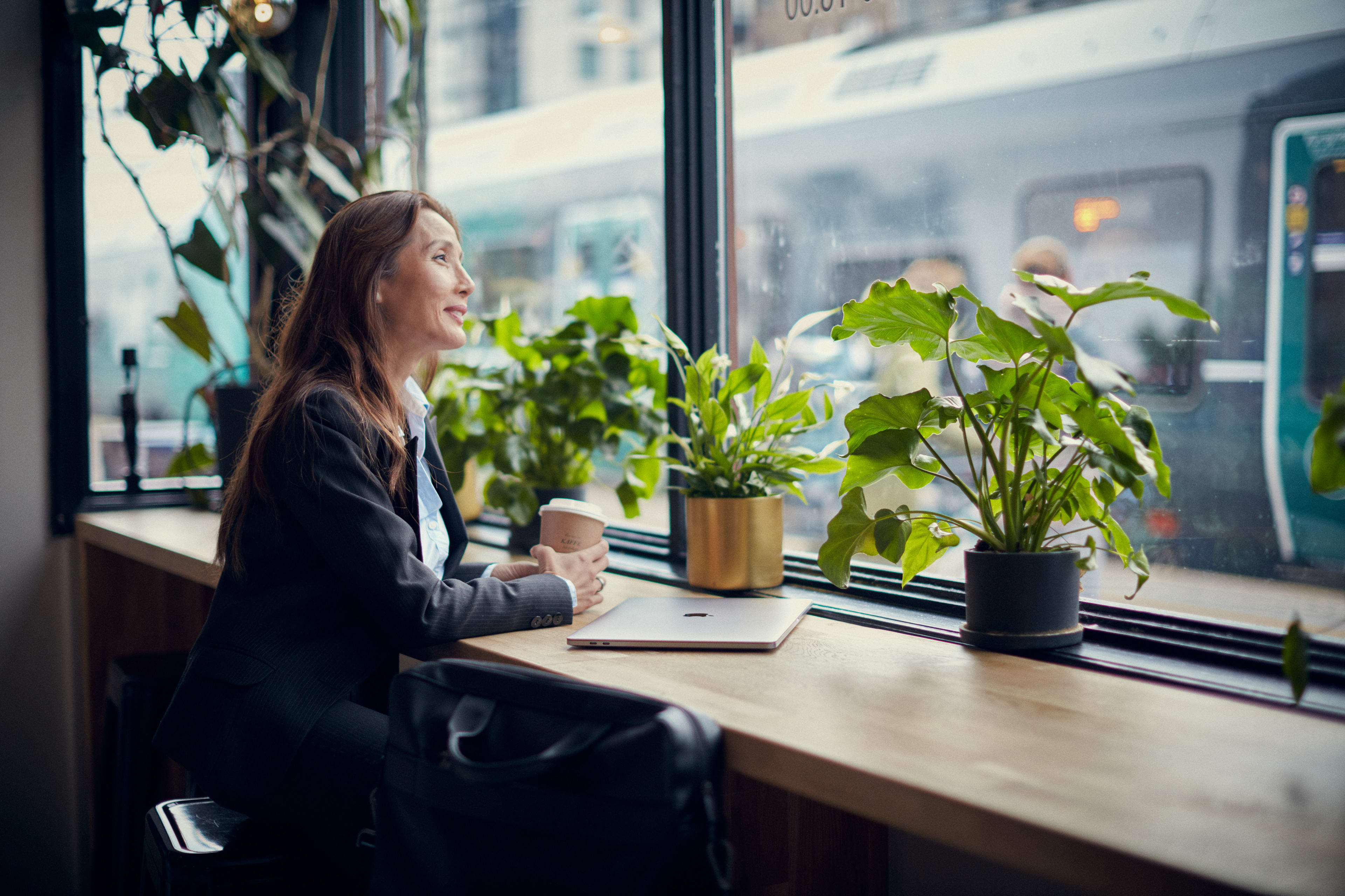 Kvinne som drikker en kaffe inne på en kafe.