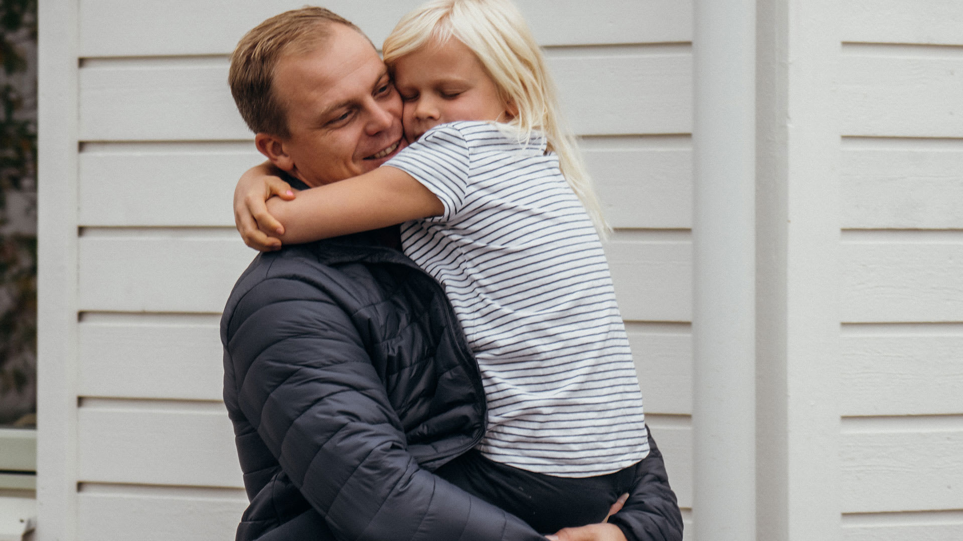 En pappa har sin dotter i famnen.