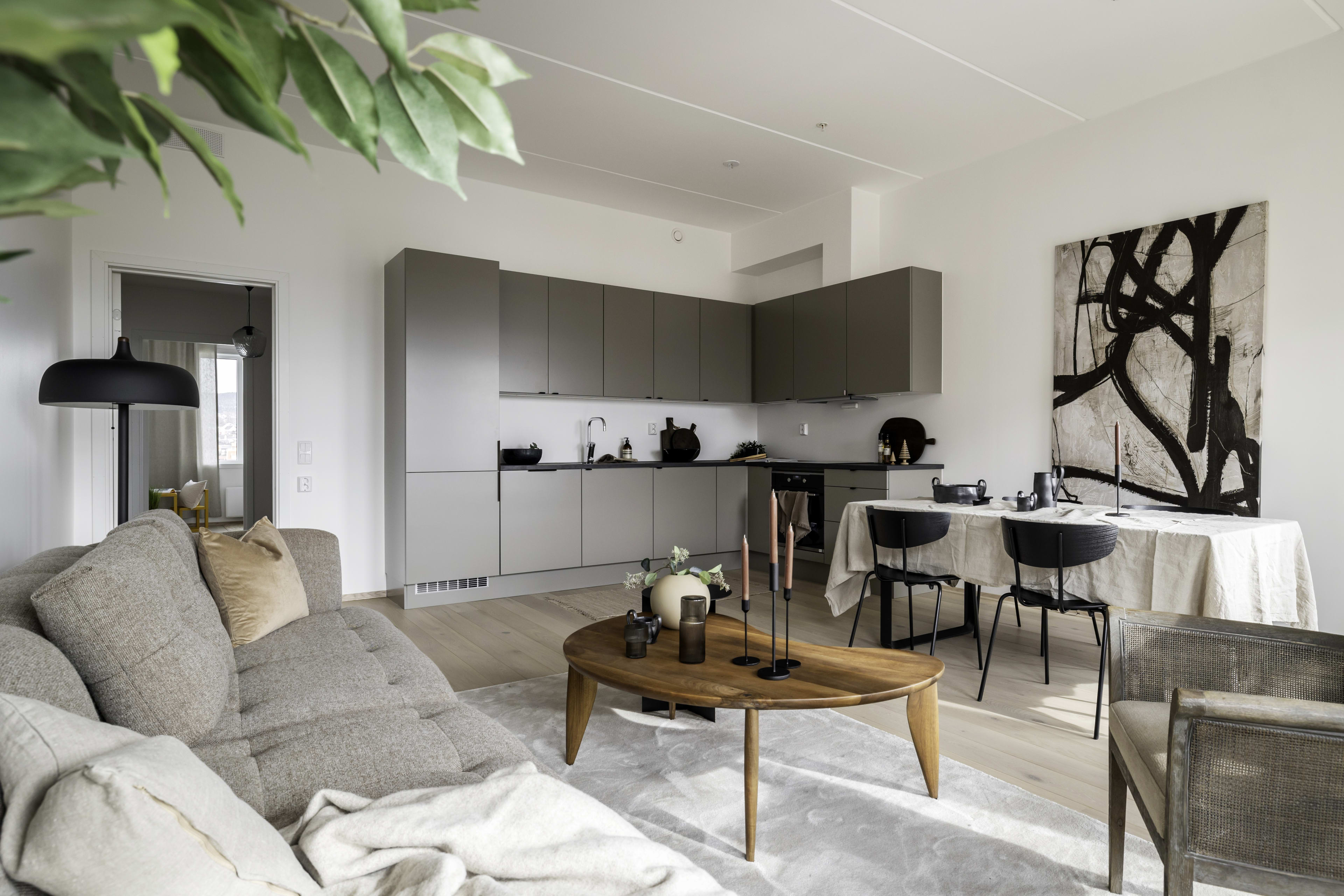 Lysmalt stue med kjøkkenhjørne og spiseplass i en leilighet i Løren botaniske