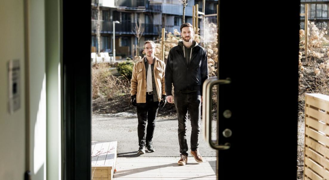 Fotografi av Mikkel og Sebastian som åpner døra med OBOS-Nøkkel