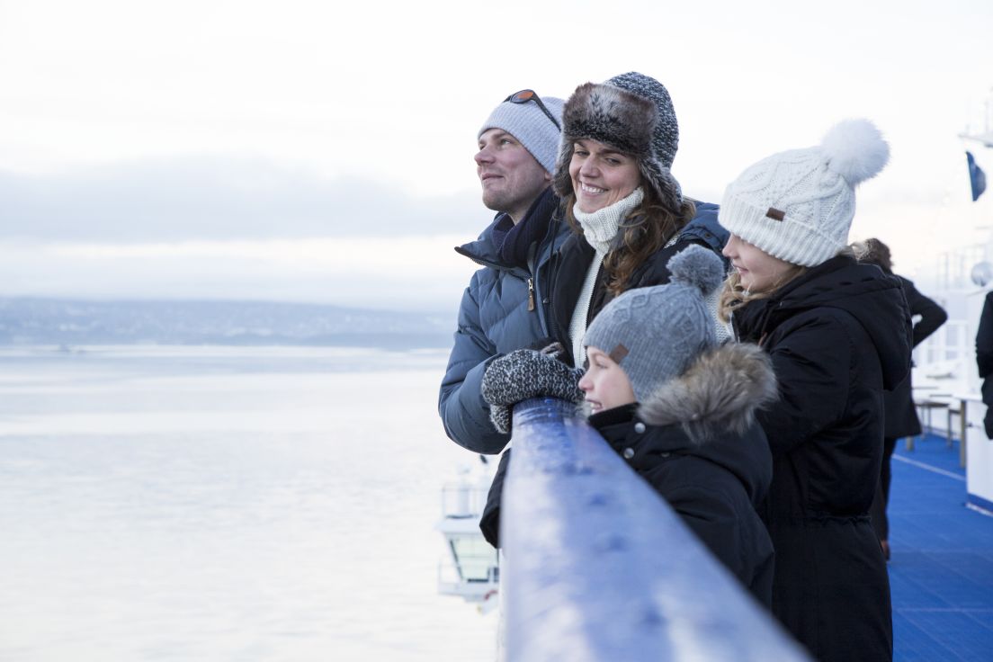 En vinterkledd familie på dekk