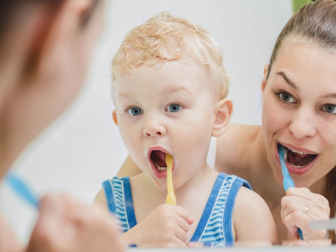 En mamma och barn borstar tänderna med färgglada tandborstar samtidigt som ljuvlig musik hörs badrumsinspiration