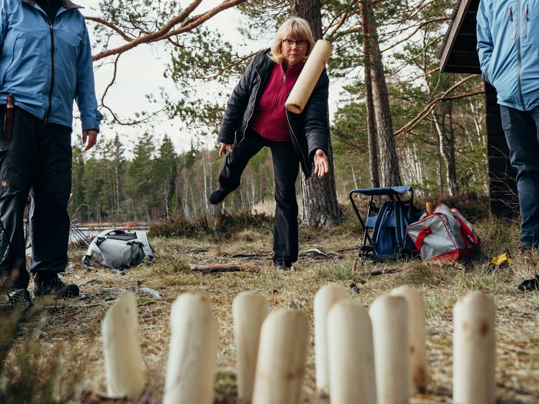 Människor som spelar kubb i skogen