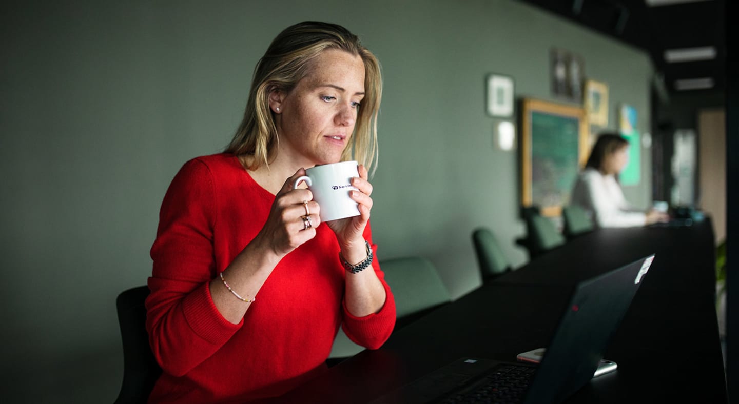 Kvinne på et kontor med kaffekopp