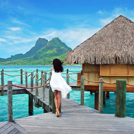 Woman overlooking the ocean from her overwater bungalow in Bora Bora