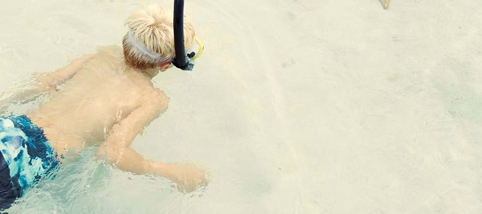 Young boy snorkelling in the clear ocean