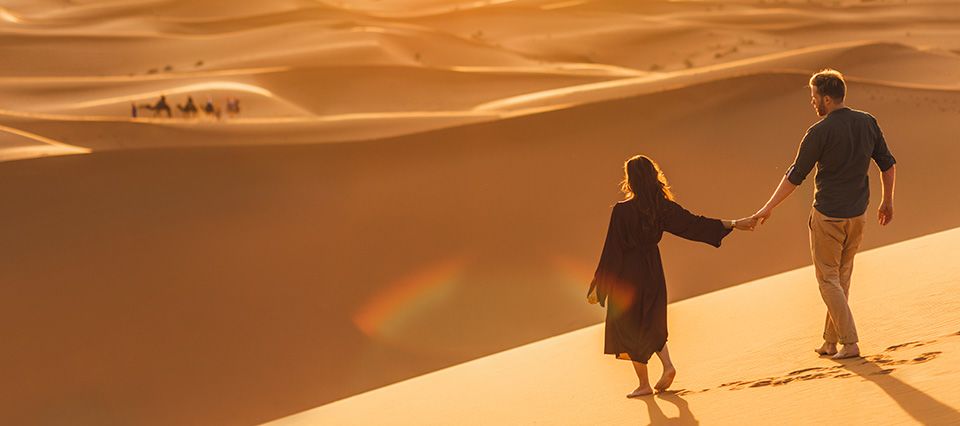 Couple admiring shelving sand dunes in Dubai