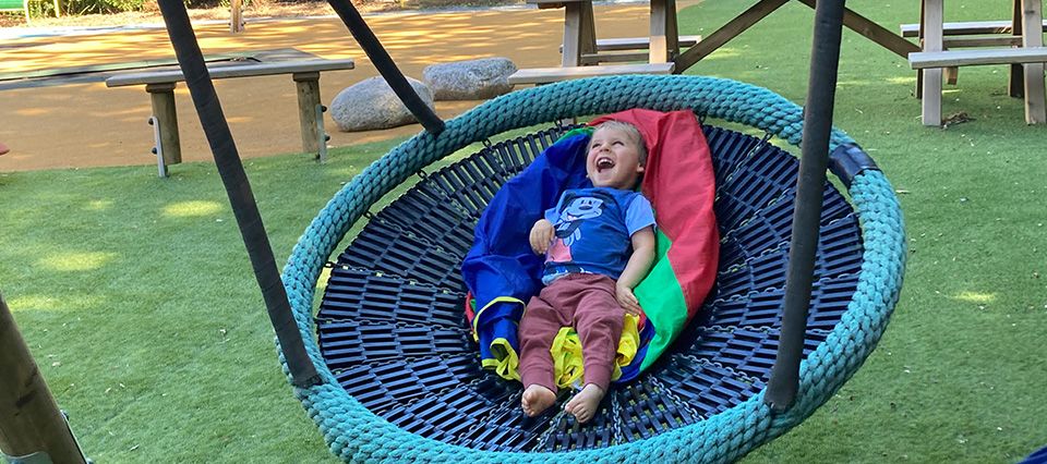 A happy child enjoying the swing at Haven House Children's Hospice