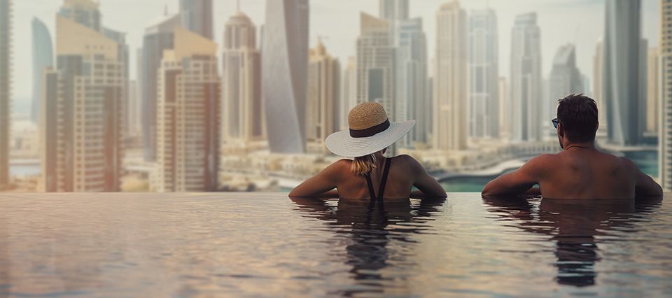 Couple in pool overlooking Dubai skyline