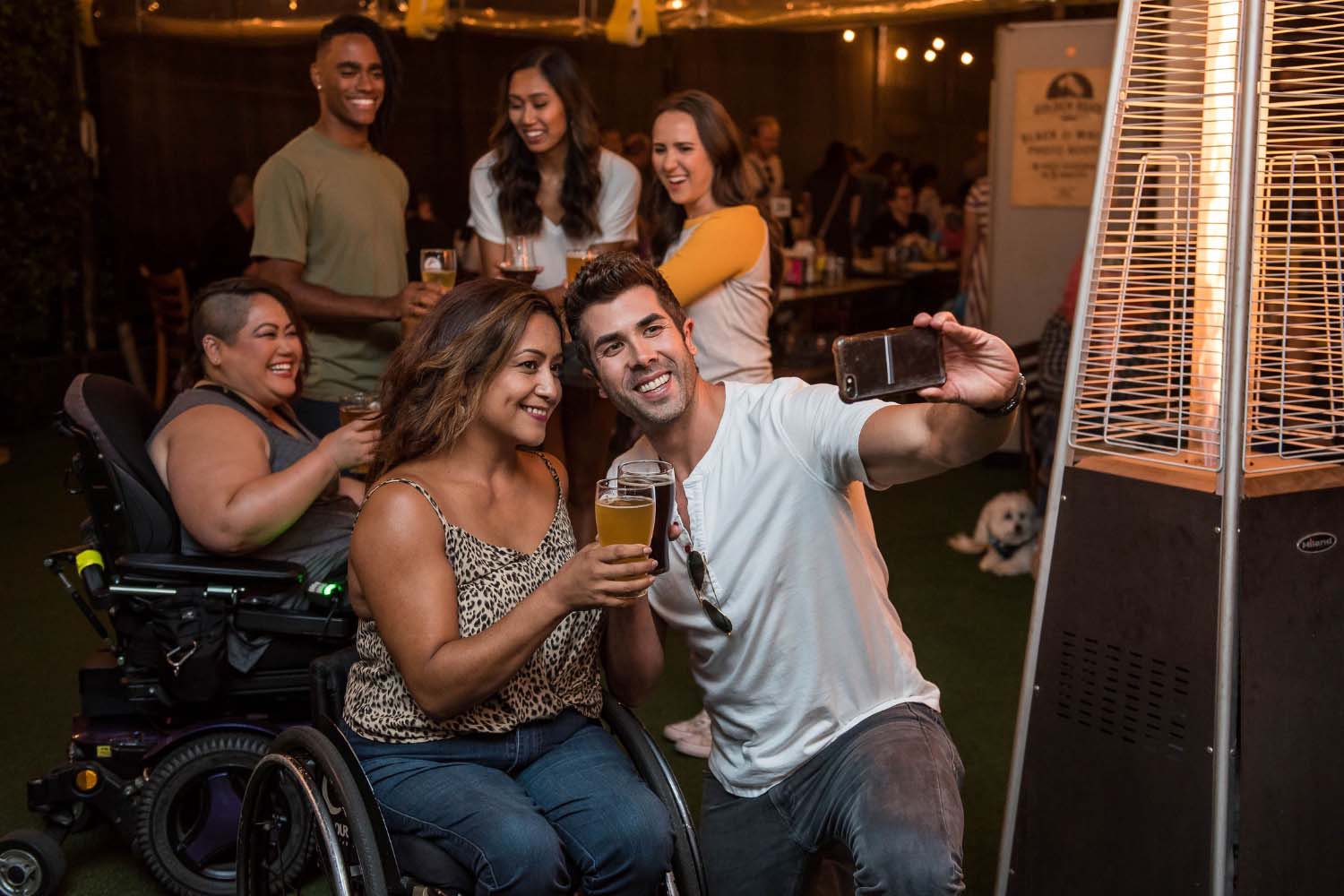 A woman in a wheelchair enjoying a drink with her friends