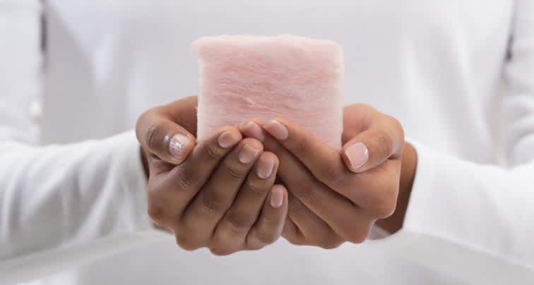 Hands holding a piece of PINK Next Gen™ Fiberglas™ Insulation