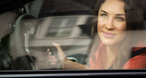 Photo of a woman looking out of her car window