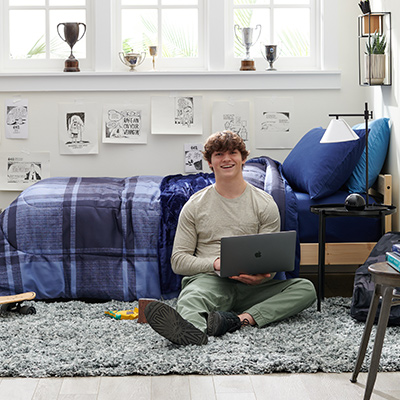 Student on his dorm with laptop