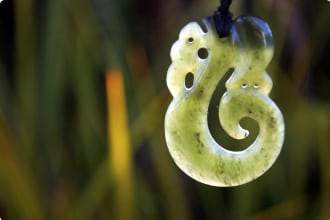 Typical Maori Pounamu with Native Flora Background