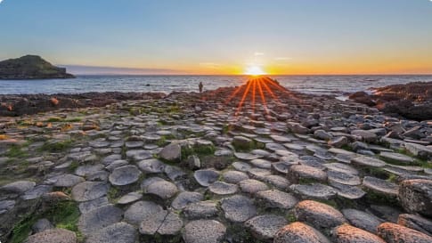 Tourist at Sunset over Giants Causeway, Northern Ireland