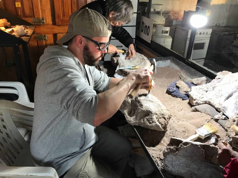 John Pickrell with the femur of thigh bone of a massive sauropod called Futalongkosaurus