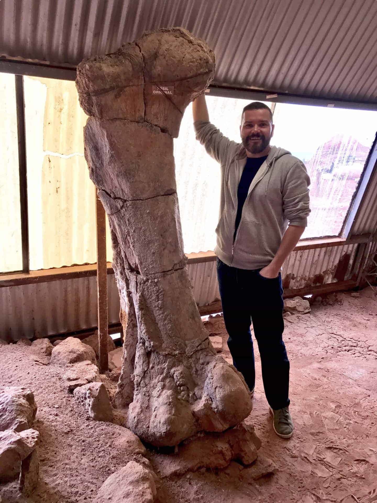 John Pickrell with the femur of thigh bone of a massive sauropod called Futalongkosaurus