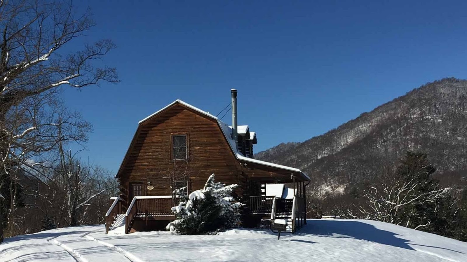 The Mt. Mitchell Log Cabin at Engadine Inn & Cabins rests in a field of snow. 