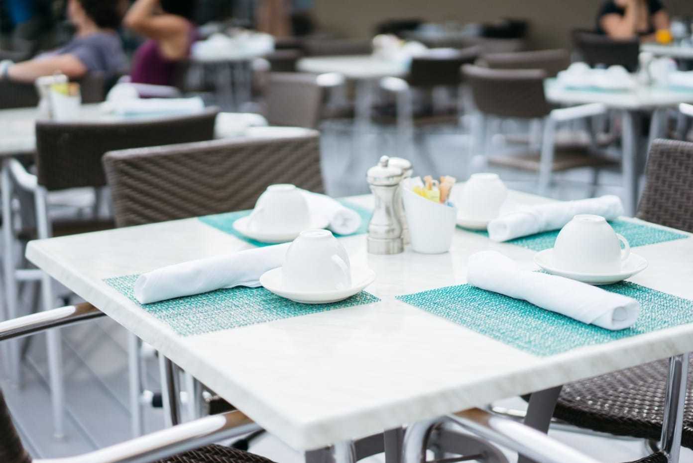 white table outdoors set with blue placemats