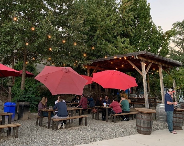 burial beer patio outdoors wood tables red umbrellas