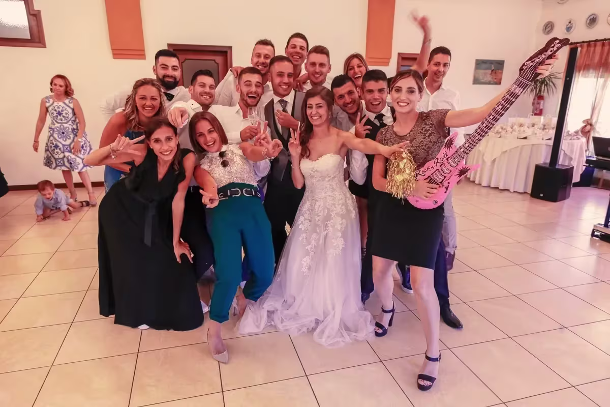 Sposi e invitati in posa con chitarre gonfiabili sulla pista di Villa dei Dogi, Caorle
