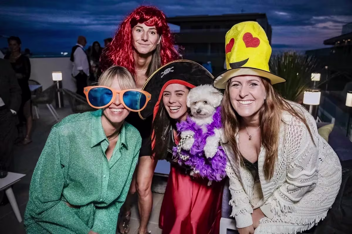 Invitati con occhiali giganti, cappelli e una parrucca rossa sulla terrazza del J44 di Jesolo