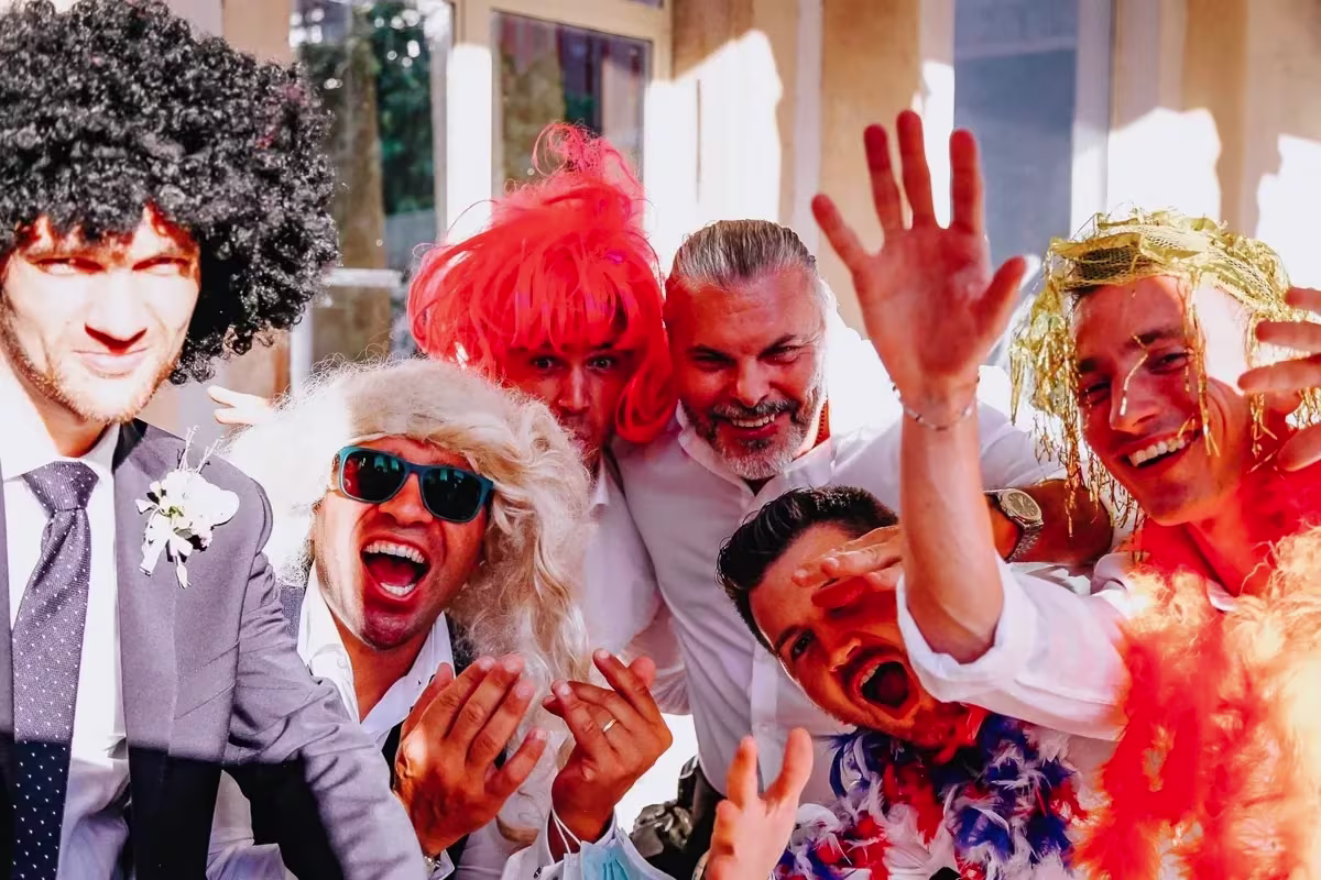 Amici con parrucche afro e colorate che urlano verso l’obiettivo a Villa Sagredo, Conselve