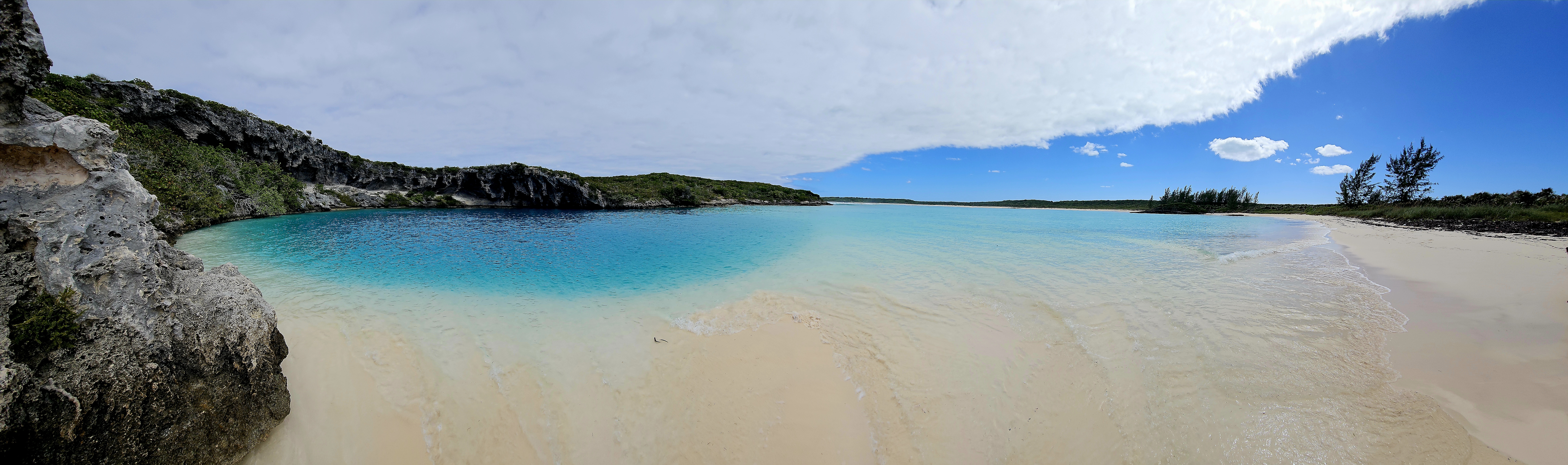 Panoramic view of a pristine secluded cove with turquoise water
