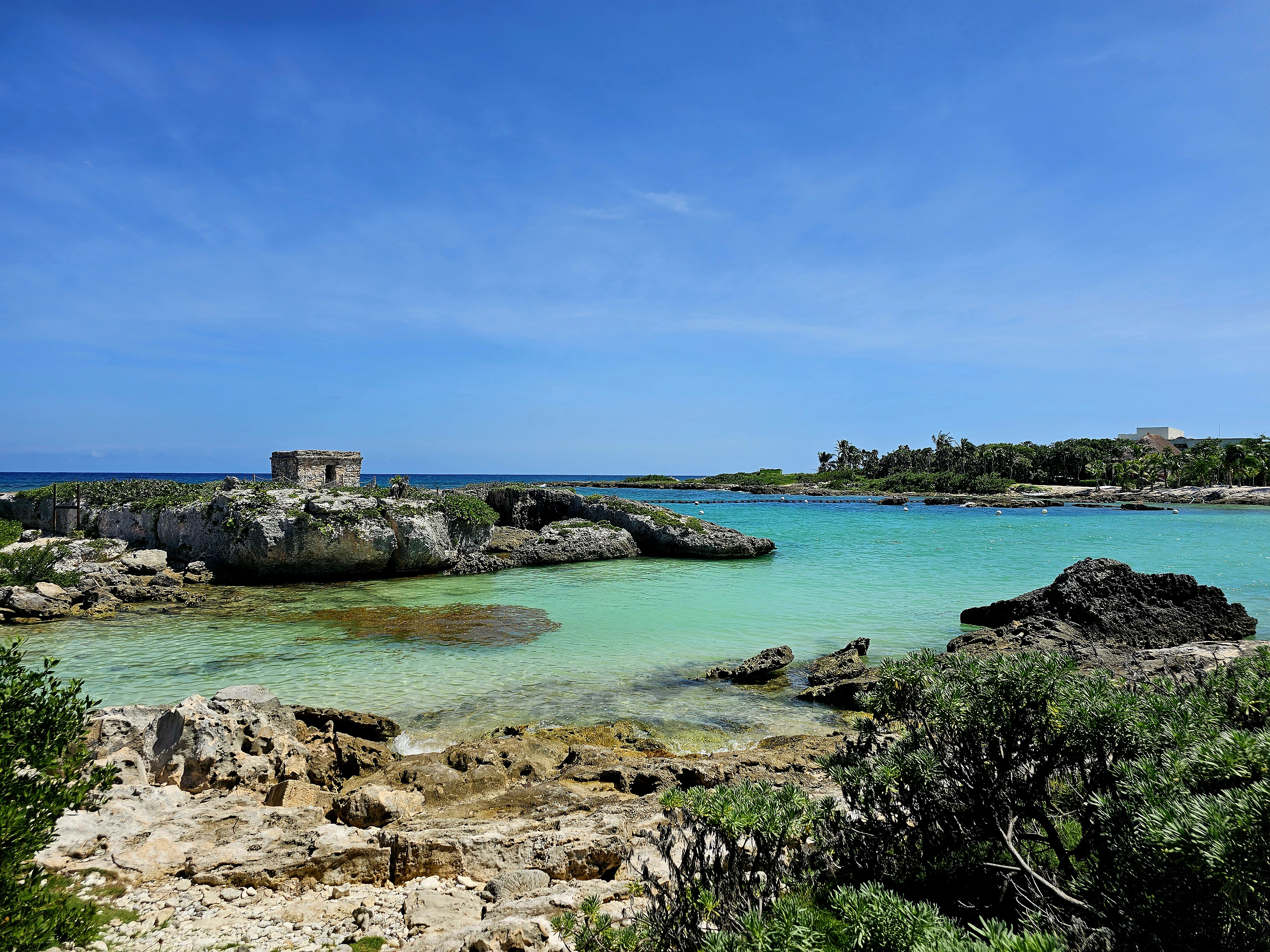 Ancient Tulum ruins on a cliff above a stunning turquoise bay