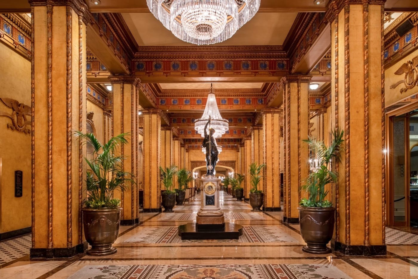 Le hall d'un pâté de maisons de long de The Roosevelt New Orleans, colonnes dorées et lustres en cristal