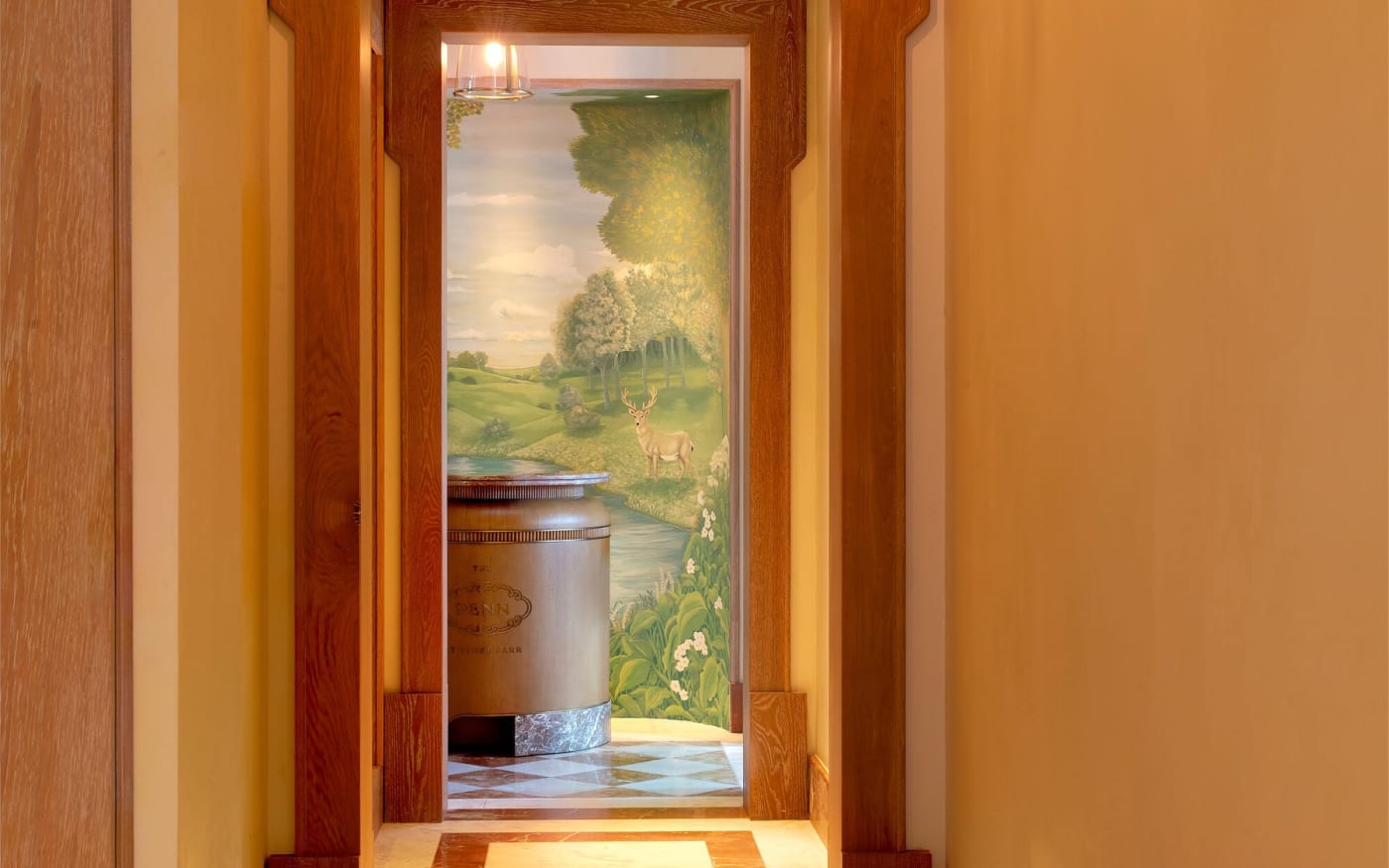The entrance doors of The Penn at Stoke Park opening onto a pastoral mural