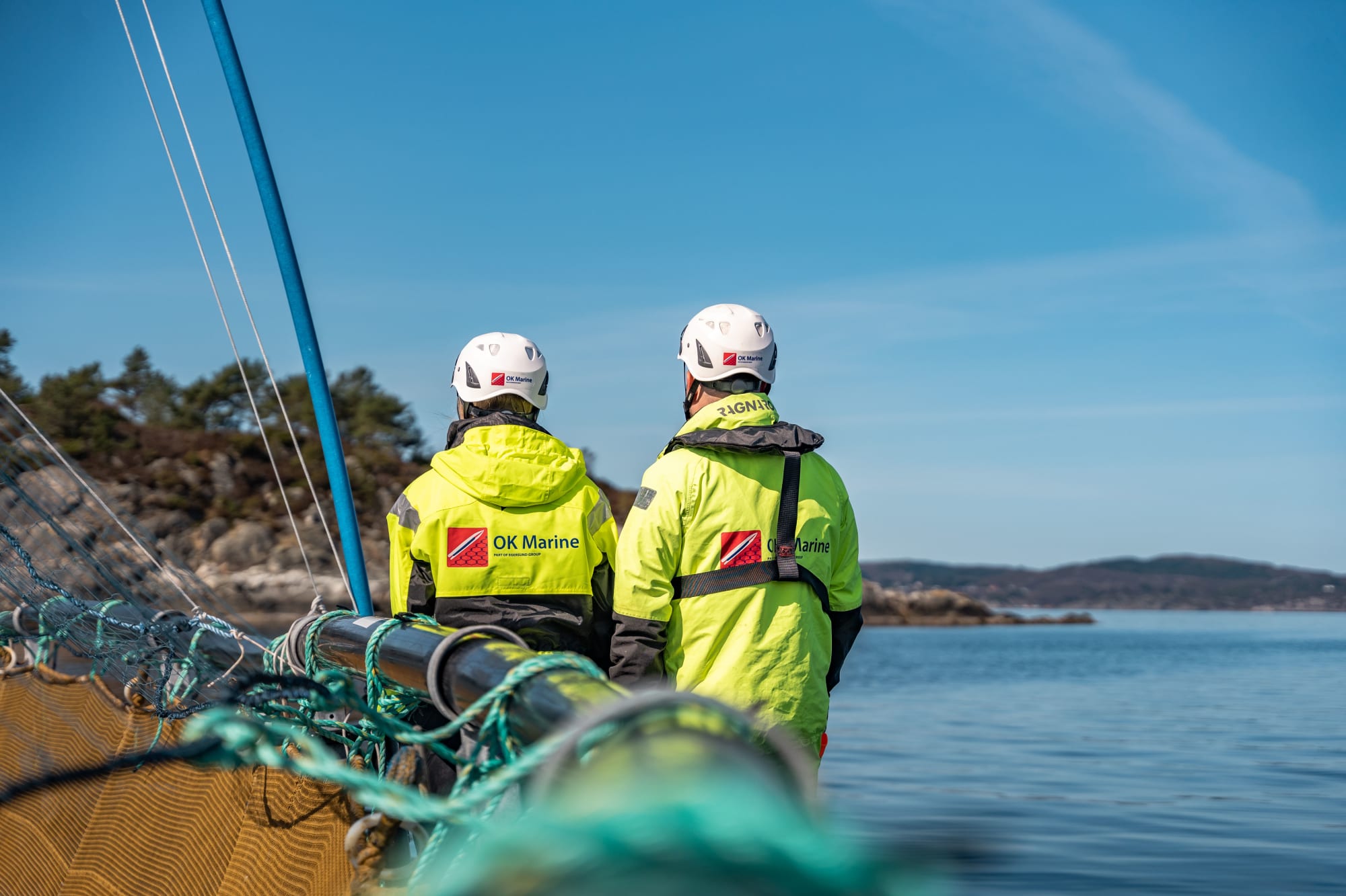 To ansatte fra OK Marine ved en merd