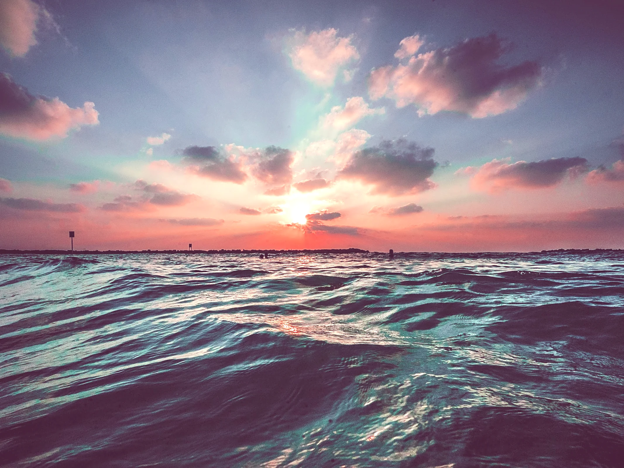 An image of a sunset over a large body of water, by @jbcreate_ on Unsplash.