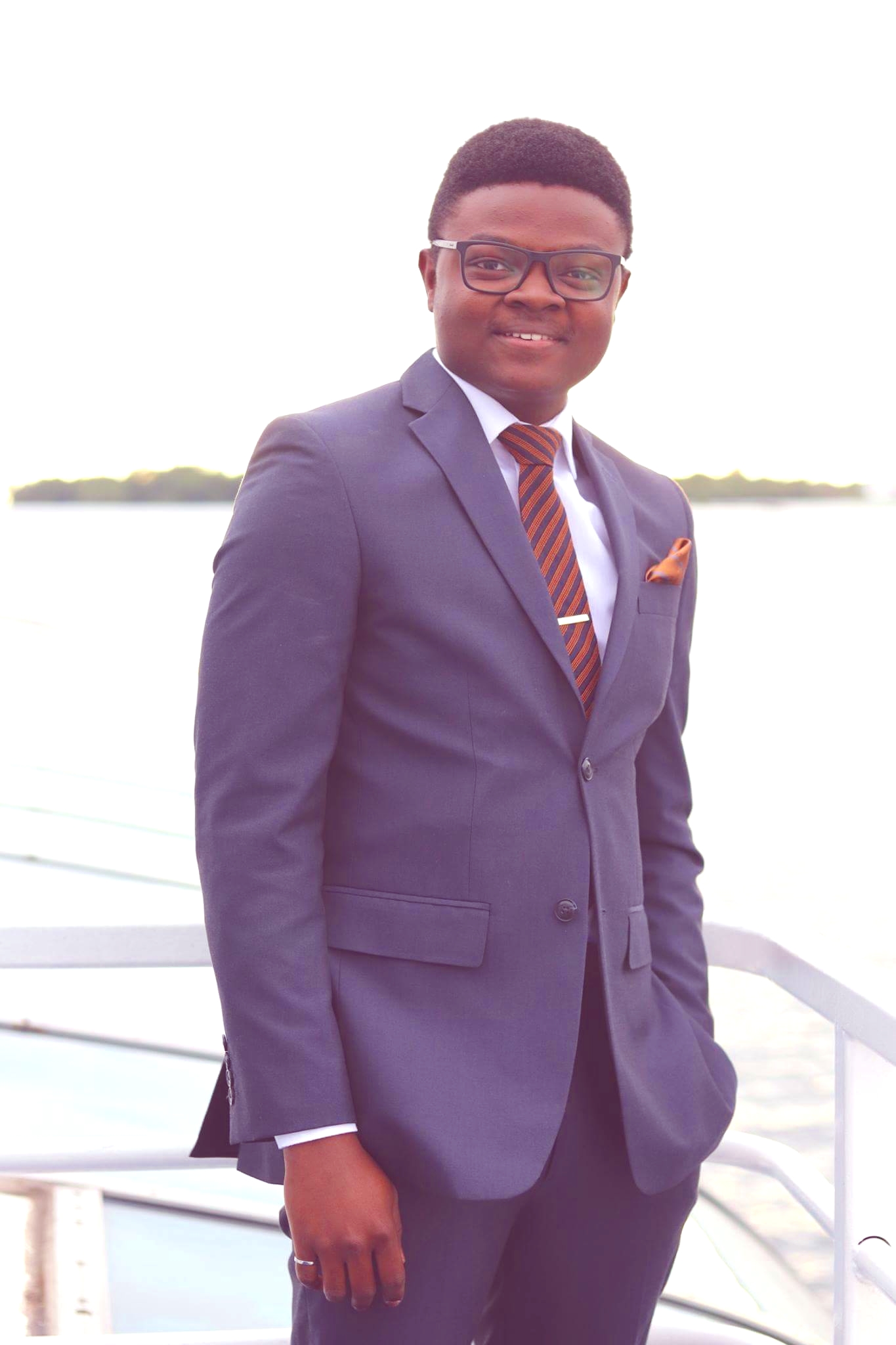 An image of Joseph Ojo in a suit on a boat.