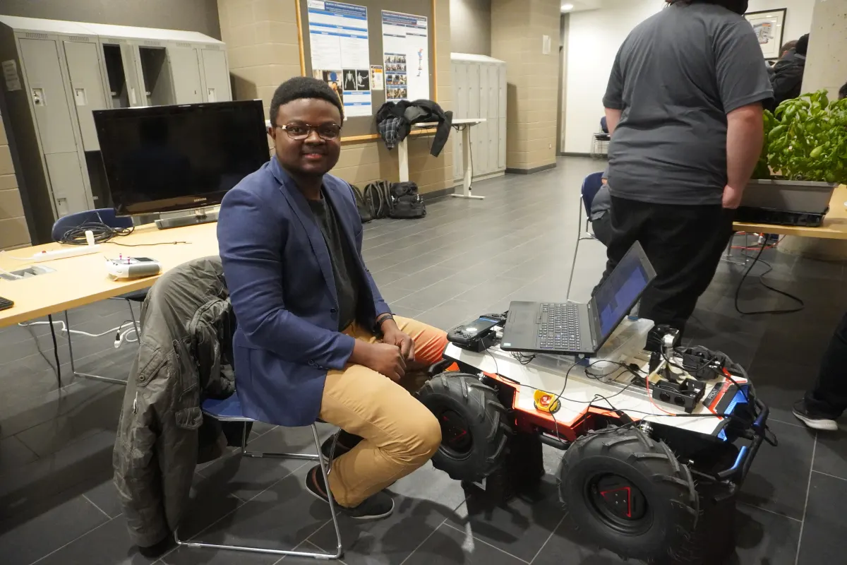 Image of Joseph Ojo working on the early development prototype robot