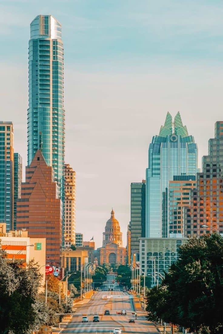 Downtown Austin skyline seen down Congress Avenue, with the Texas State Capitol dome at the end of the street.