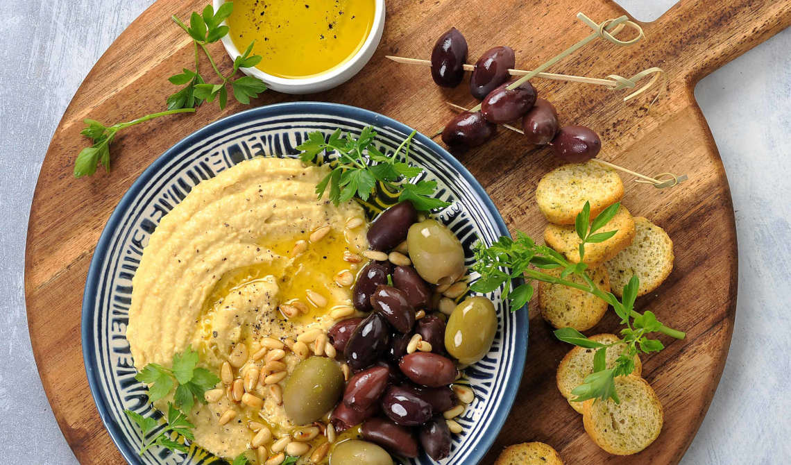 Hjemmelaget hummus med oliven og ristede pinjekjerner