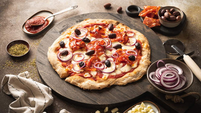 Pizza med salami, oliven og rødløk