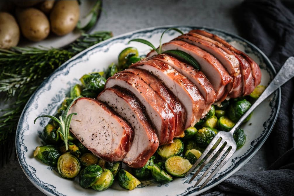 Stekt kalkunbryst surret inn i Prosciutto de Parma, dandert på en seng av rosenkål.