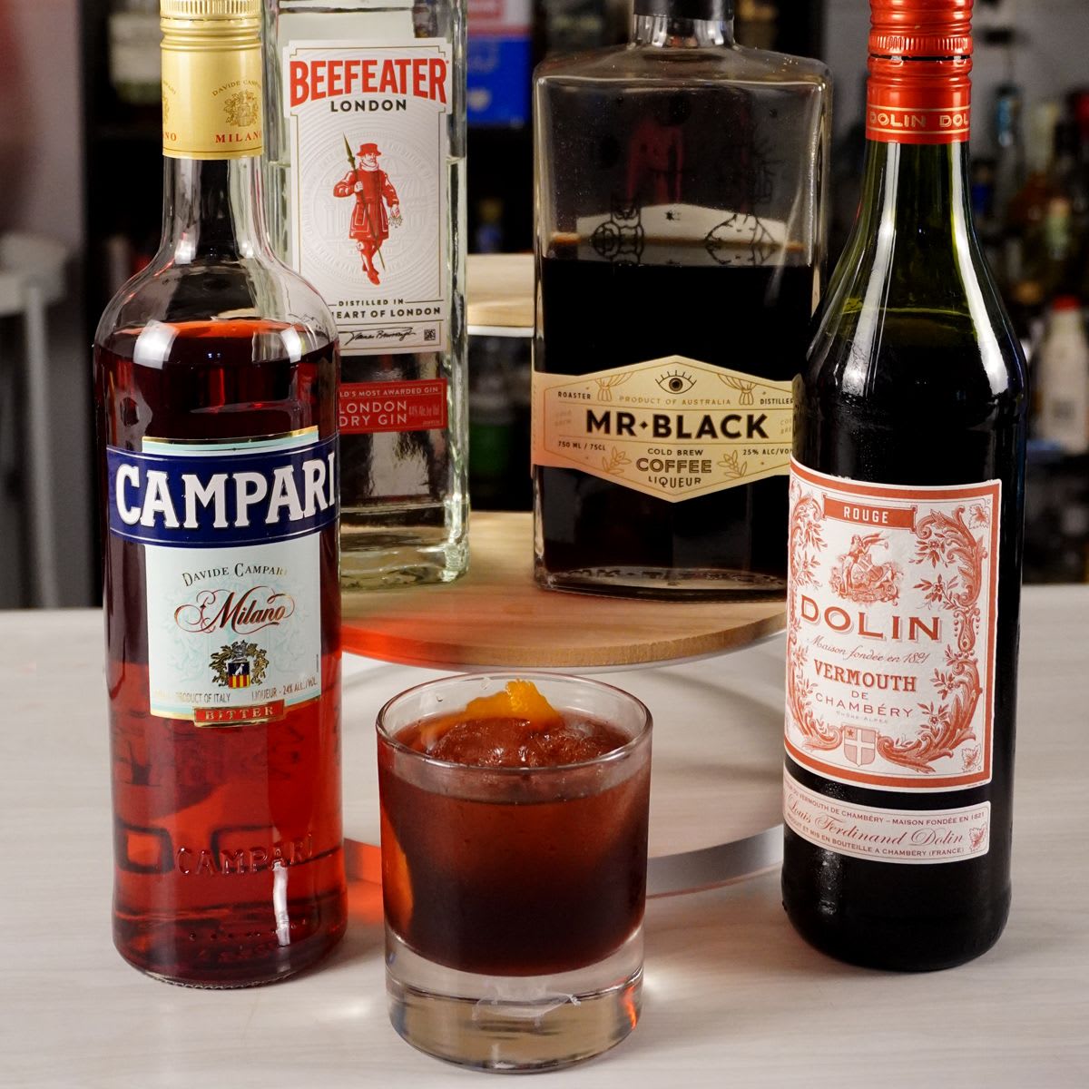 Coffee Negroni with Mr Black cold brew coffee liqueur, gin, Campari, and sweet vermouth, served over an ice sphere with an orange peel