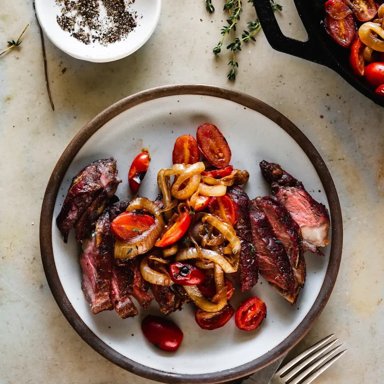 Grilled Garlic and Thyme Strip Steaks with Seared Onions and Tomatoes