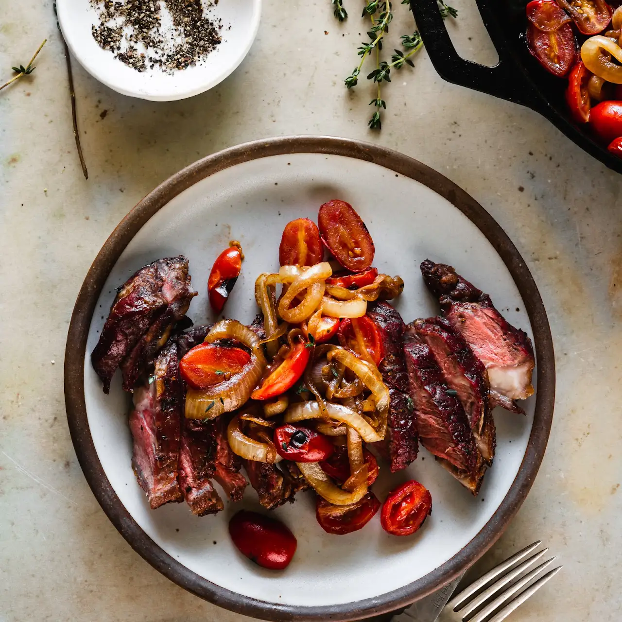 Grilled Garlic and Thyme Strip Steaks with Seared Onions and Tomatoes cover